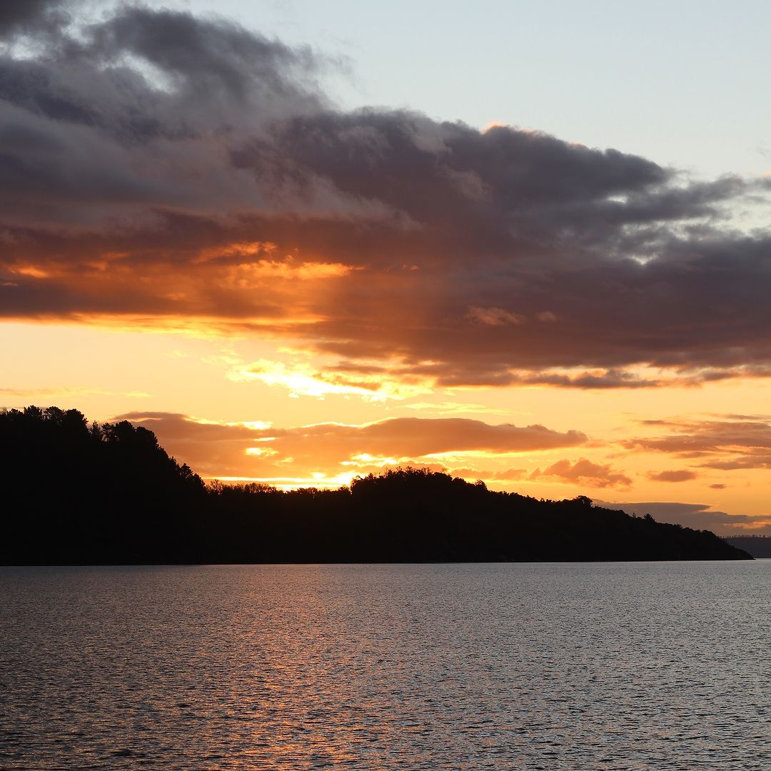Atardecer sobre un lago y montañas en Pucón
